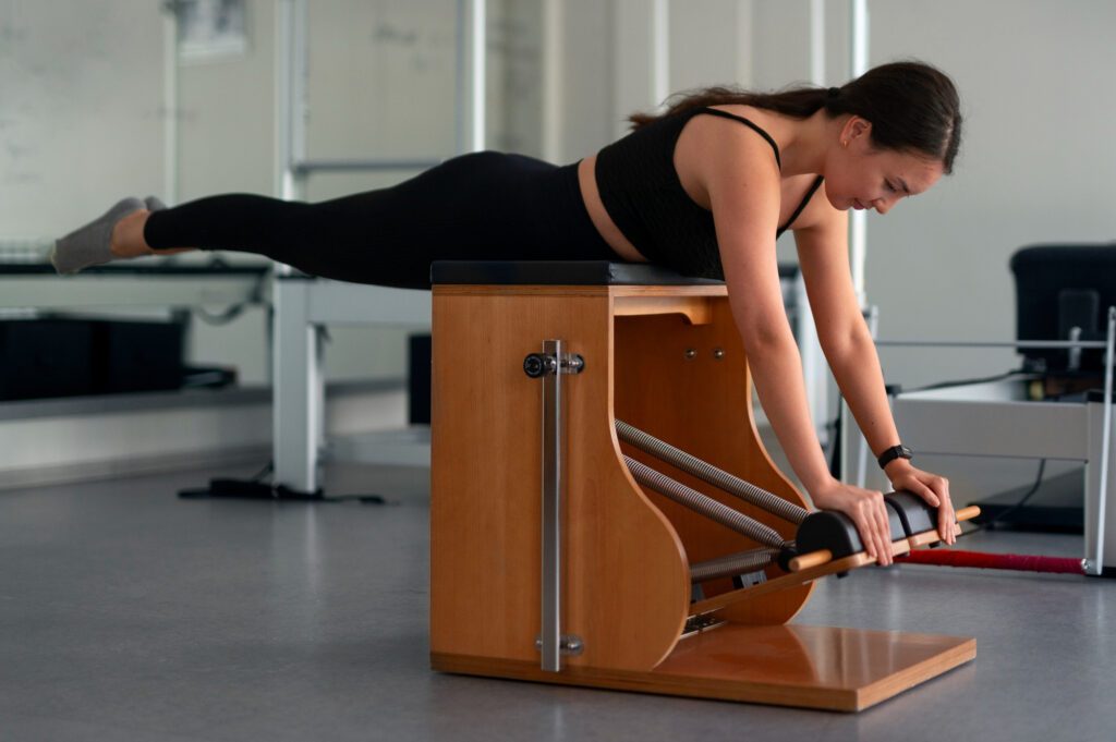 Clase de pilates con máquinas mostrando el uso de la silla (chair) wunda