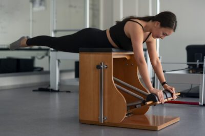 Una mujer haciendo Pilates con máquina Chair Wunda para adelgazar